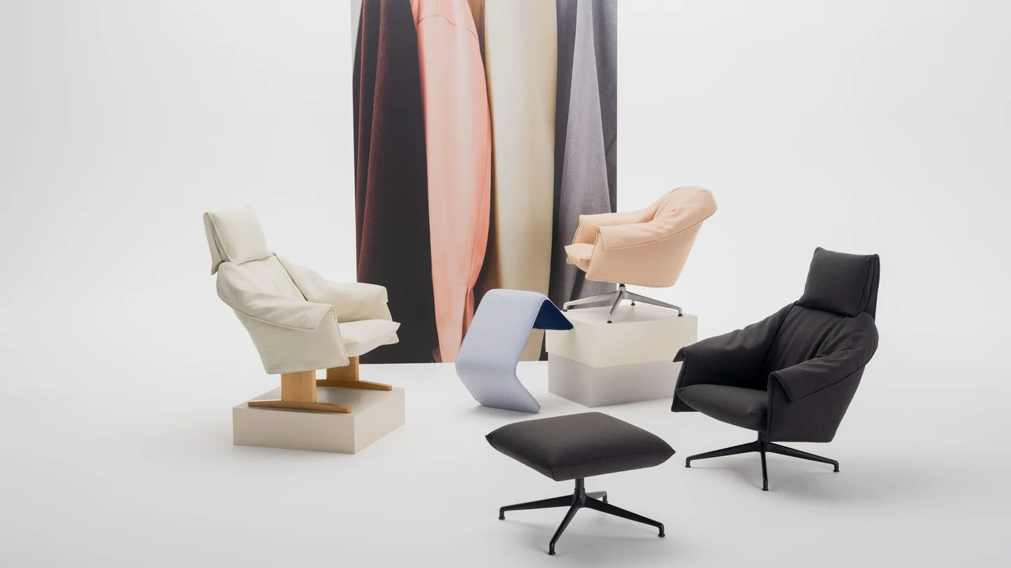 Vitra Bascule: butacas lounge y otomana en crema, melocotón y negro ante telas colgadas
